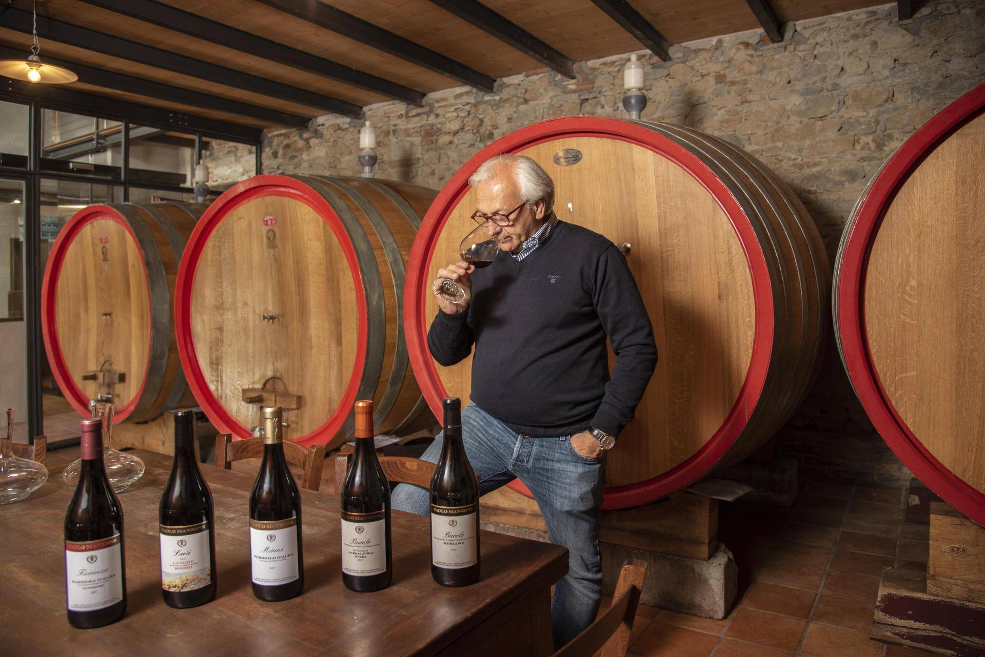 Sommelier seen from behind in front of shelves full of wine bottles